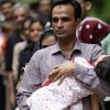 A Pakistani refugee who is a member of the Ahmadiyya community carries his daughter as he is released from a detention centre in Bangkok. PHOTO: REUTERS/ FILE
