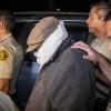 Unidentified person is escorted out of Nakoula Basseley Nakoula's home by Los Angeles County Sheriff's officers in Cerritos, California